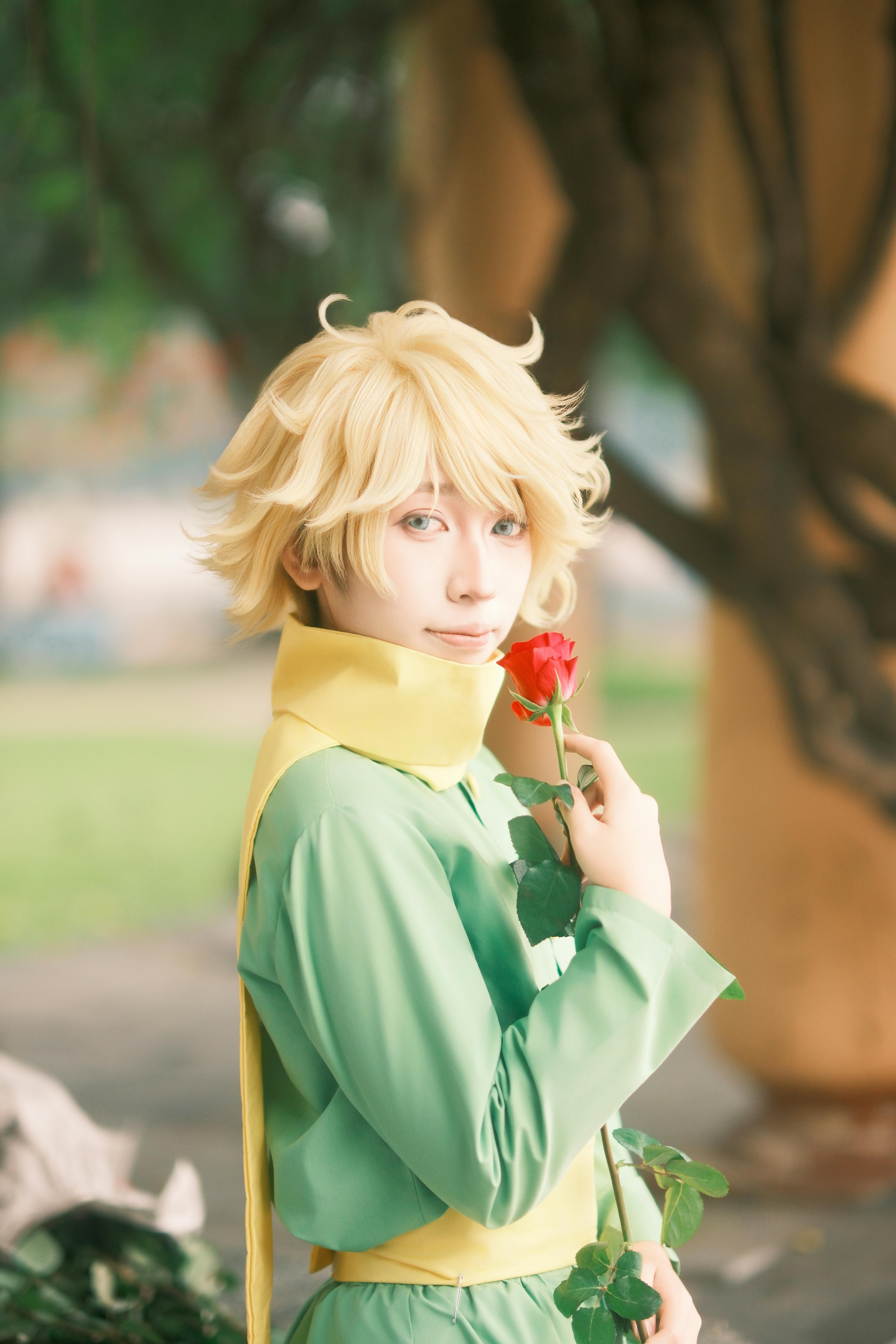 An artistic cosplay photo featuring a character holding a red rose outdoors.