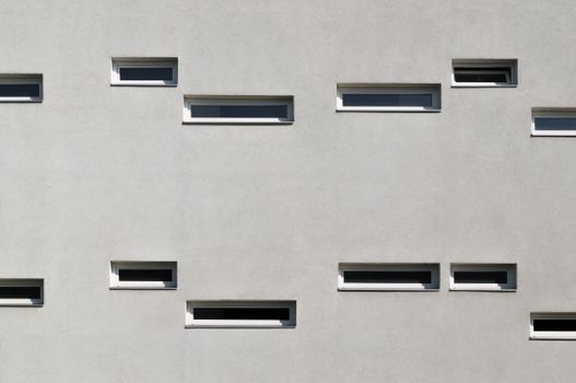 Modern building facade featuring a minimalist design with evenly spaced windows.