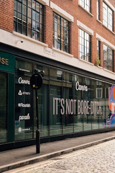 Street view of a brick building in London with a prominent Canva advertisement.