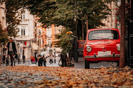 Captivating autumn scene in a Belgrade street with vintage car and fallen leaves.