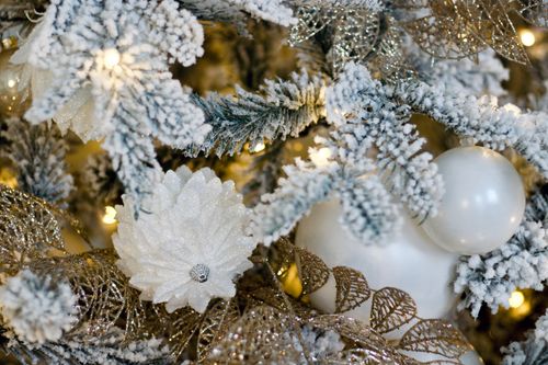 Free Close-up of a decorated Christmas tree featuring snow-covered branches and glittery ornaments. Stock Photo