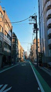Quiet street in Taito City, Tokyo, Japan with urban architecture on a clear day.