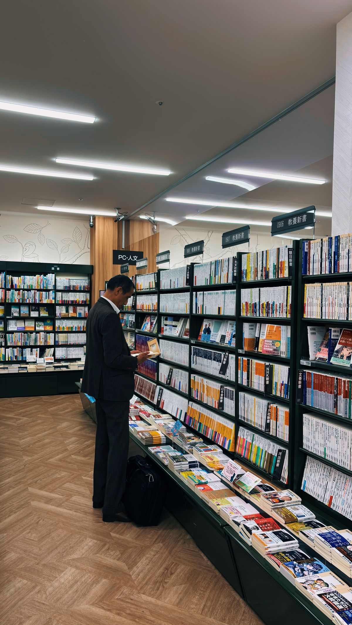 書店で資格の専門書を選ぶビジネスパーソン