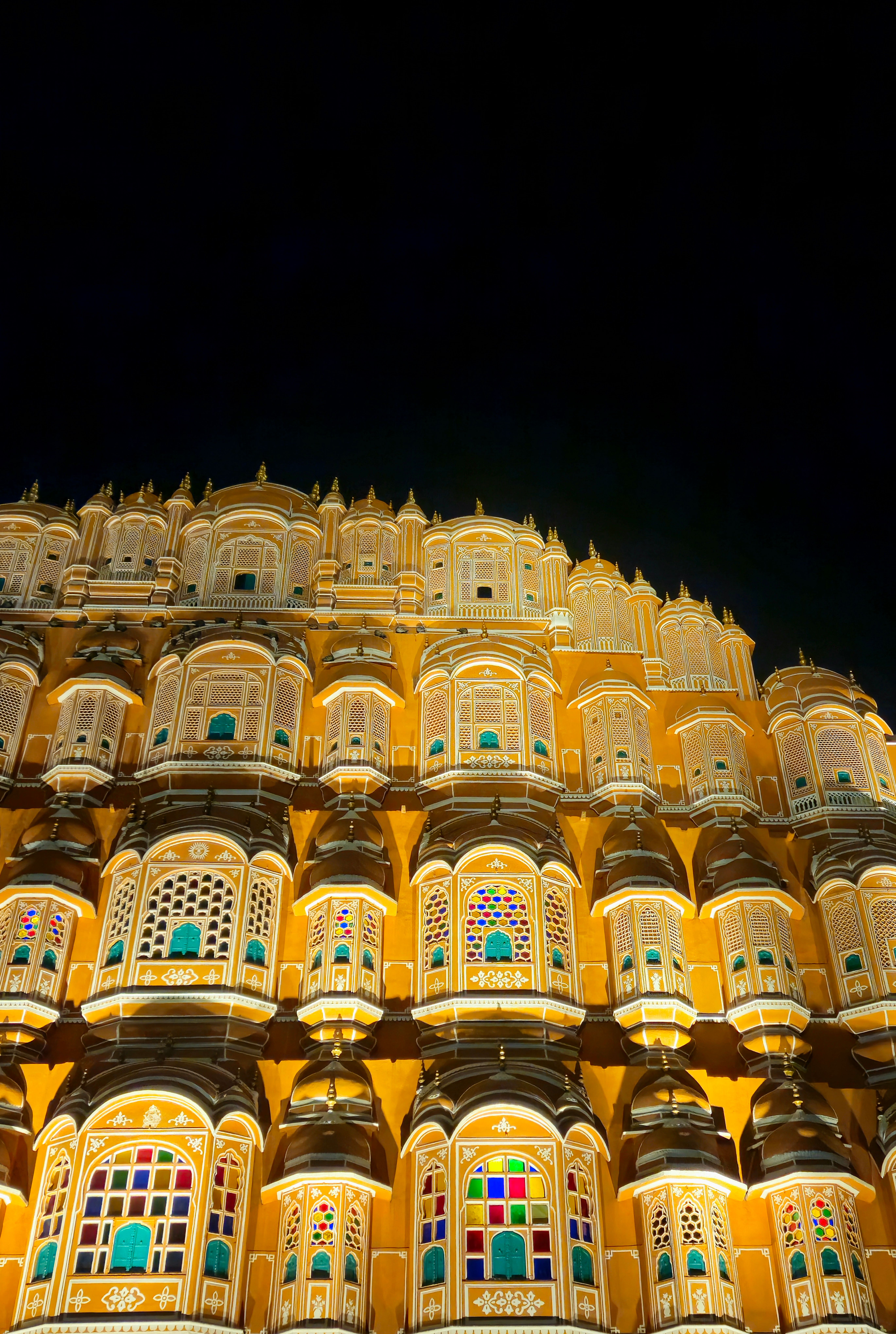 Stunning night view of Hawa Mahal's intricate architecture in Jaipur, India.