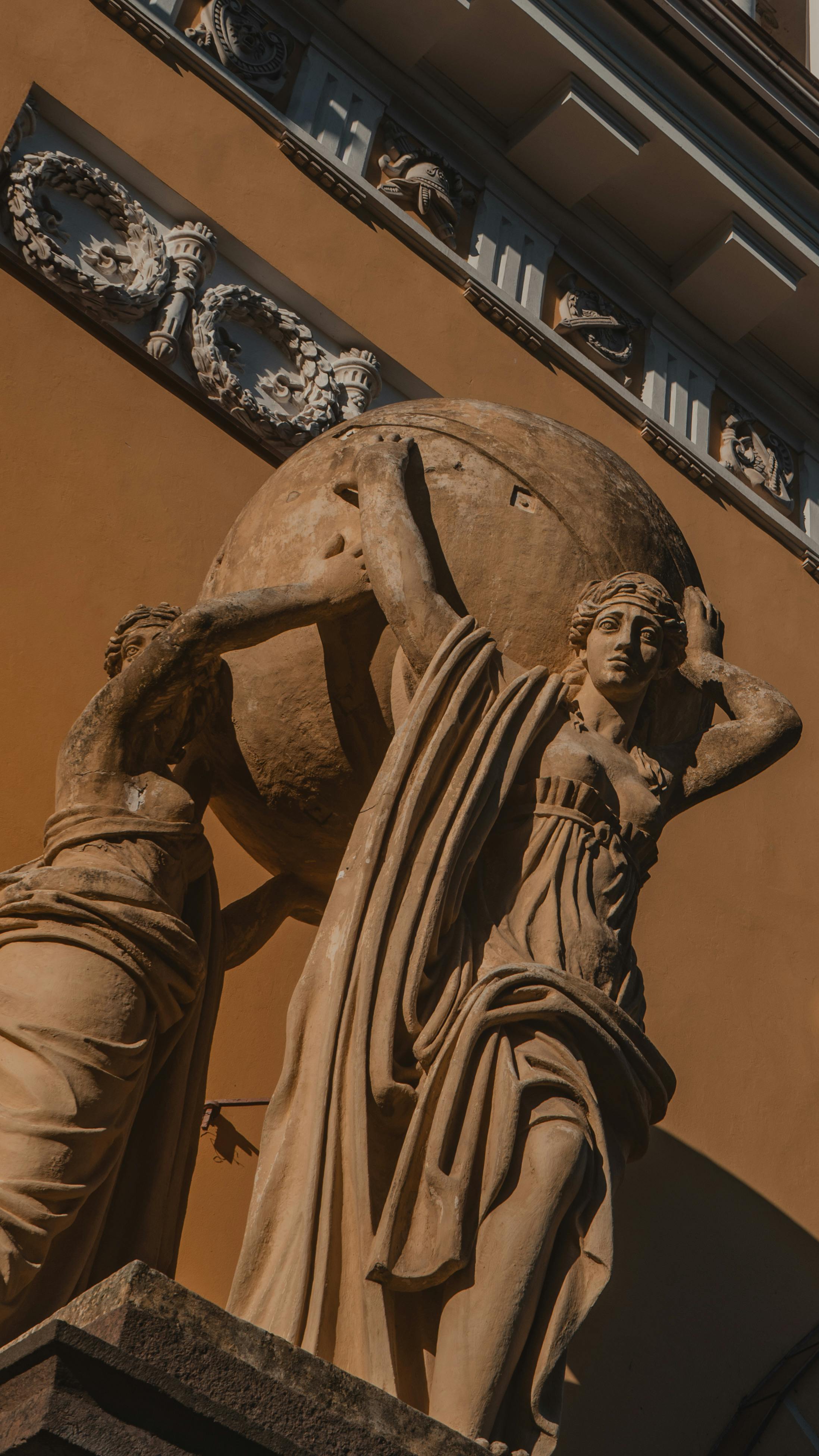 Ücretsiz Küre tutan figürleri tasvir eden Rönesans tarzı bir heykelin yakın çekimi, sıcak tonlar. Stok Fotoğraflar