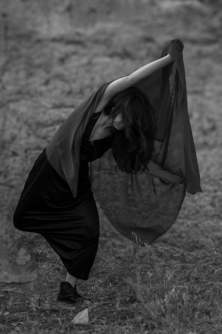 Graceful dancer in motion, embracing a flowing fabric outdoors with an artistic touch.