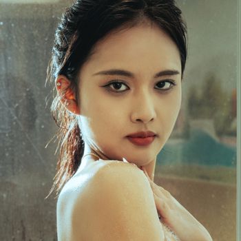 Close-up portrait of a woman with a serene expression indoors.