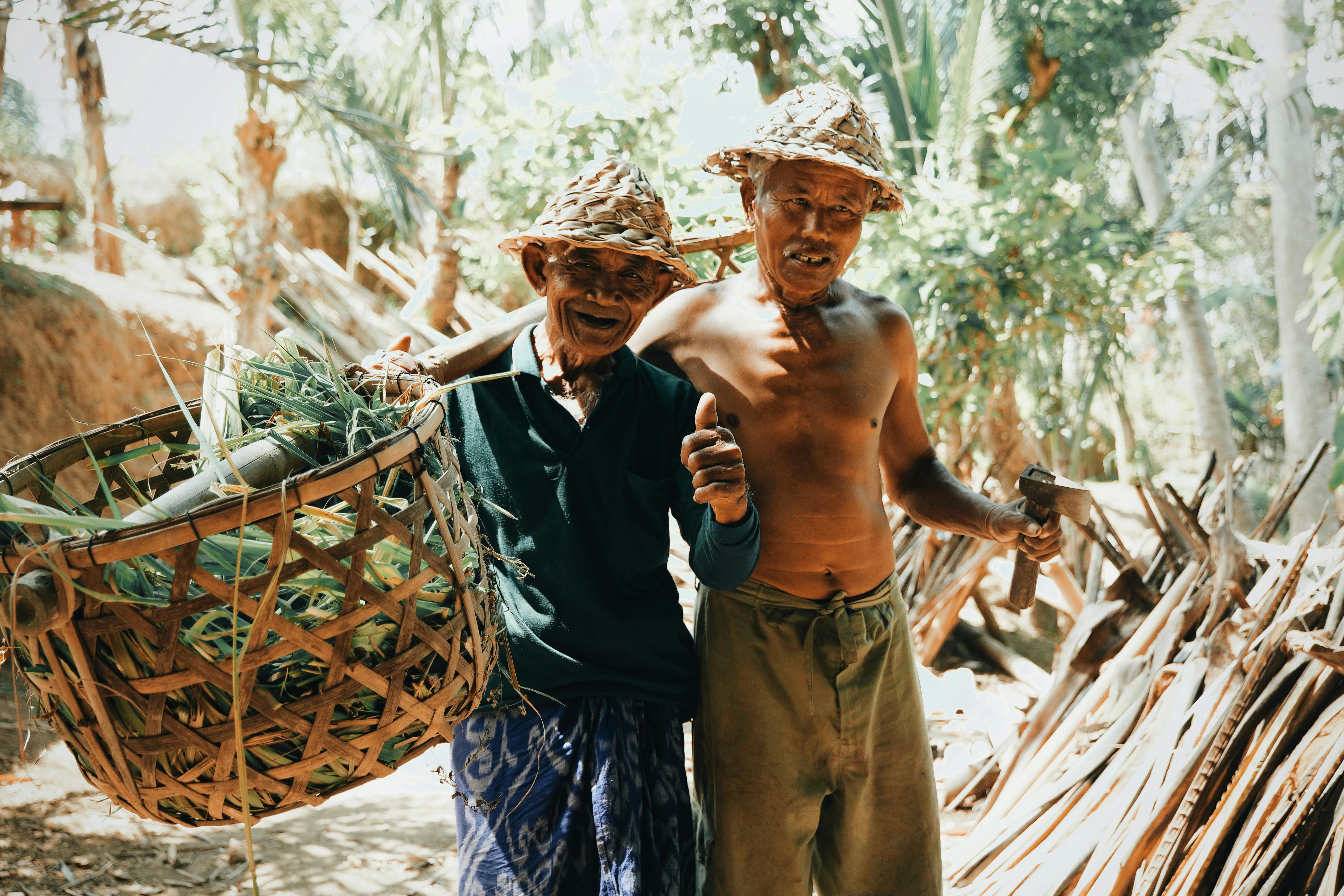 ethnic harvesters with baskets in jungle