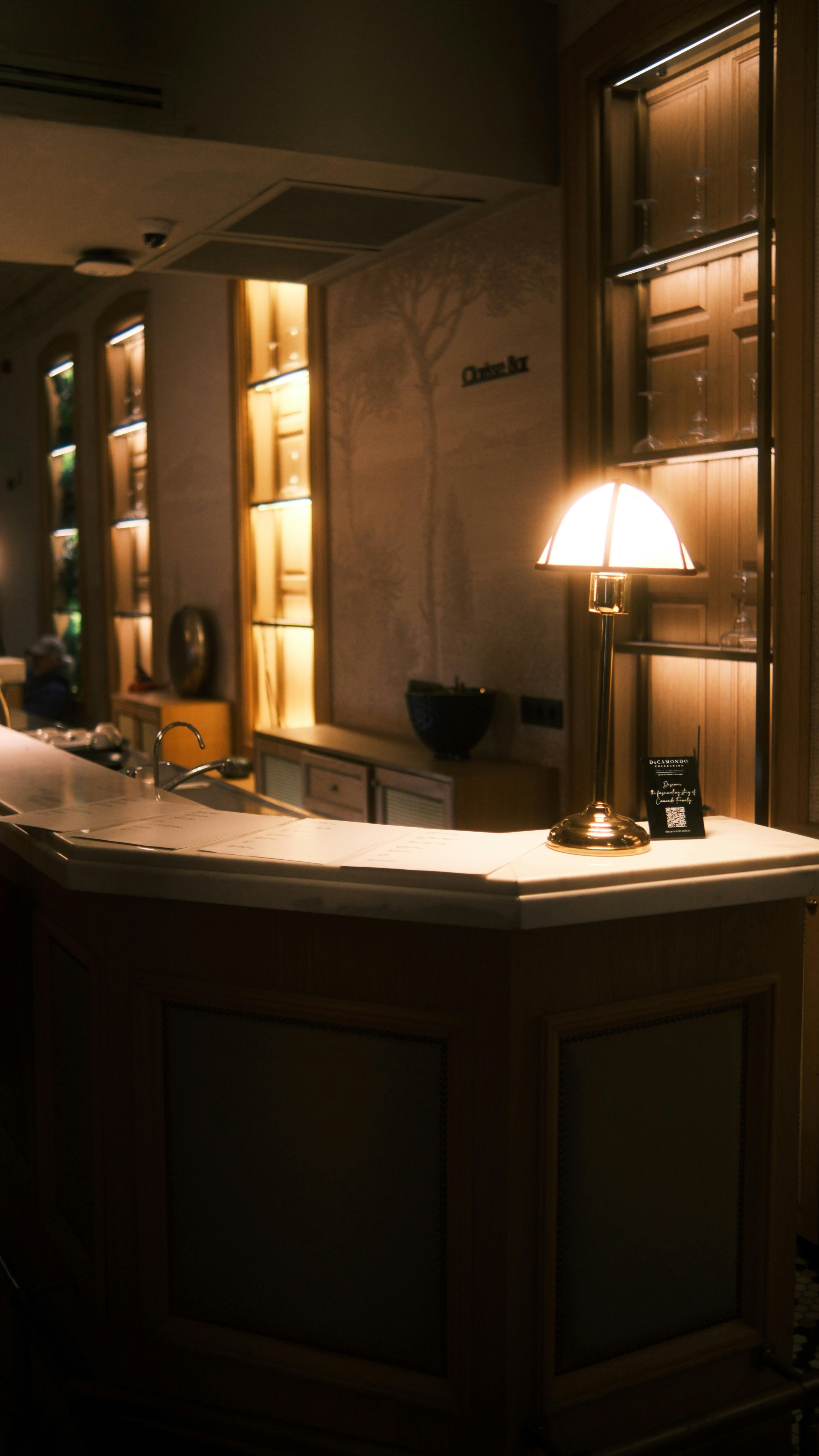 Gratuit Tejghea din holul hotelului, luminată cald, cu decor elegant și iluminare ambientală pentru o atmosferă confortabilă. Fotografie de stoc