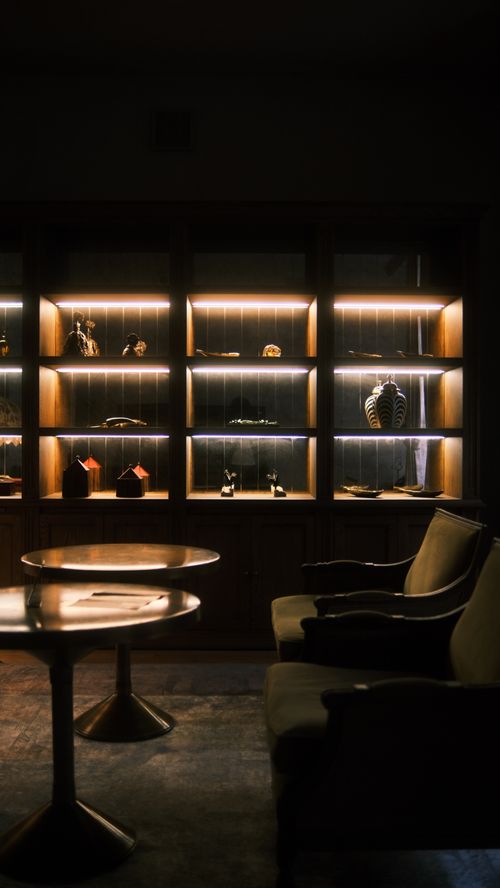 Free Explore a sophisticated lounge interior with elegant armchairs and a styled display cabinet. Stock Photo