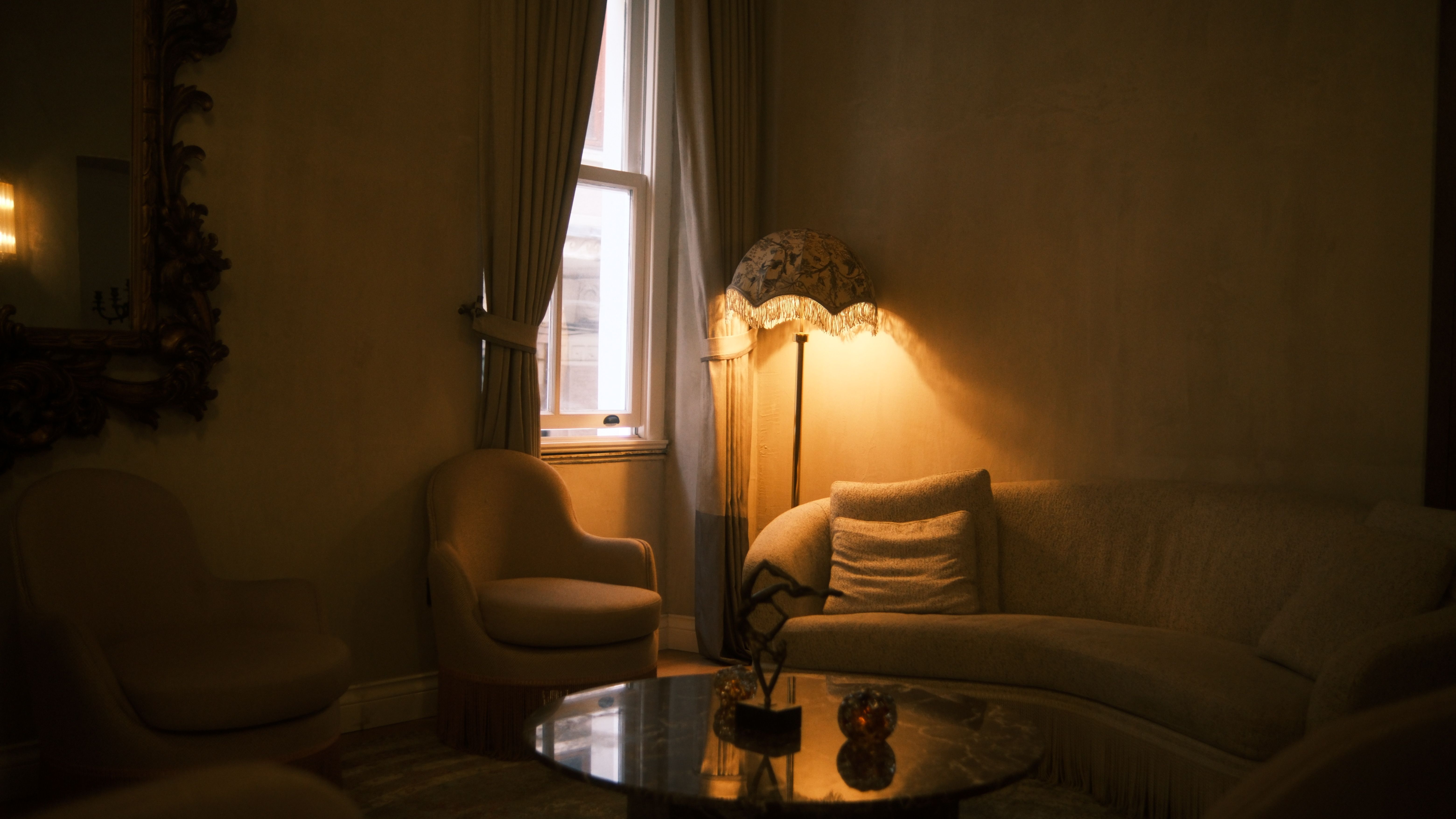 Free A softly lit living room featuring plush seating and an elegant floor lamp. Stock Photo