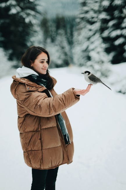 Woman Wearing Brown Coat While Holding Bird