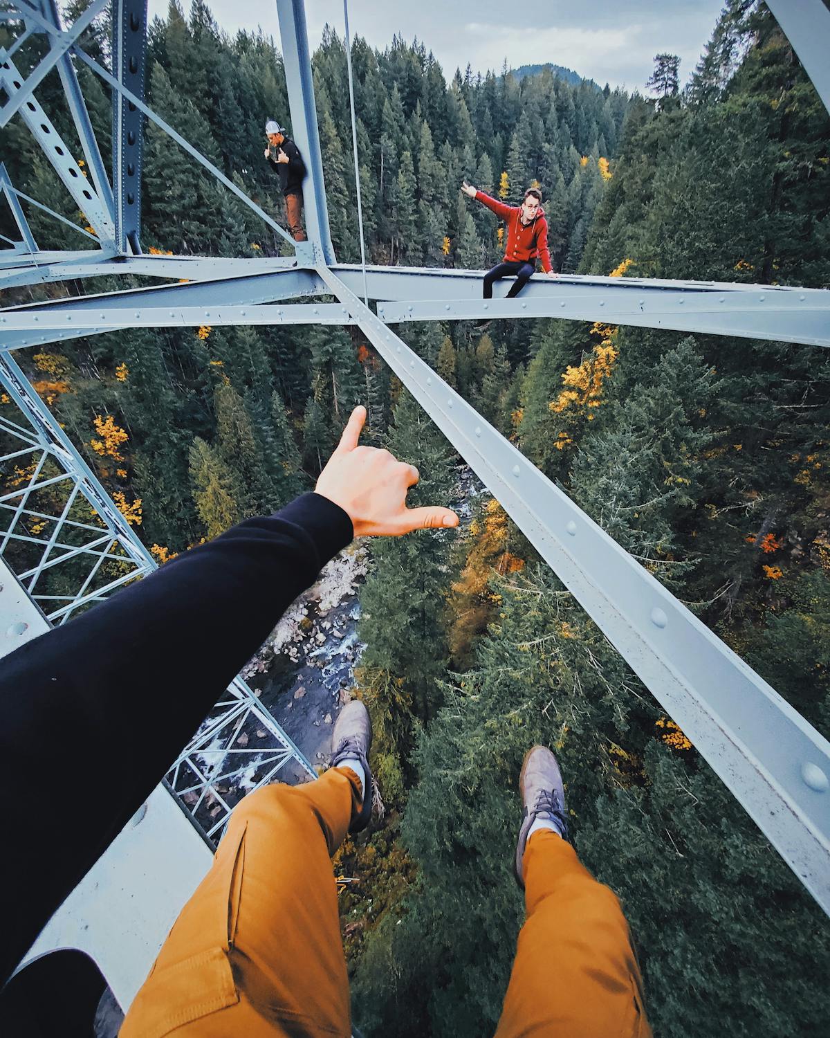 Persona in pantaloni neri e scarpe marroni vista dal basso sul ponte