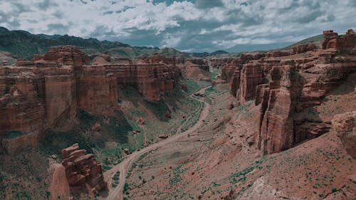 Panoramic view of rough canyon mountains with curvy road running away in valley below