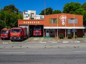 A fire station with red fire trucks in Colonia del Sacramento, Uruguay, on a sunny day.