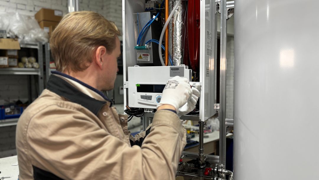A technician working on a heating unit indoors