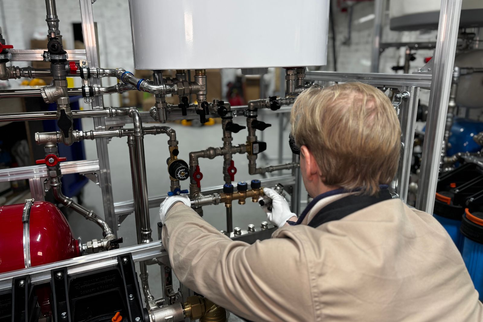 Engineer adjusting valves on a manifold of insulated mechanical piping