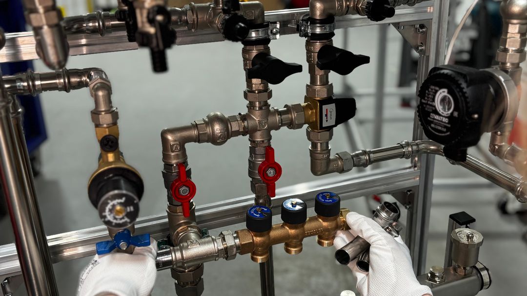 A technician adjusting valves on a run of water treatment pipework