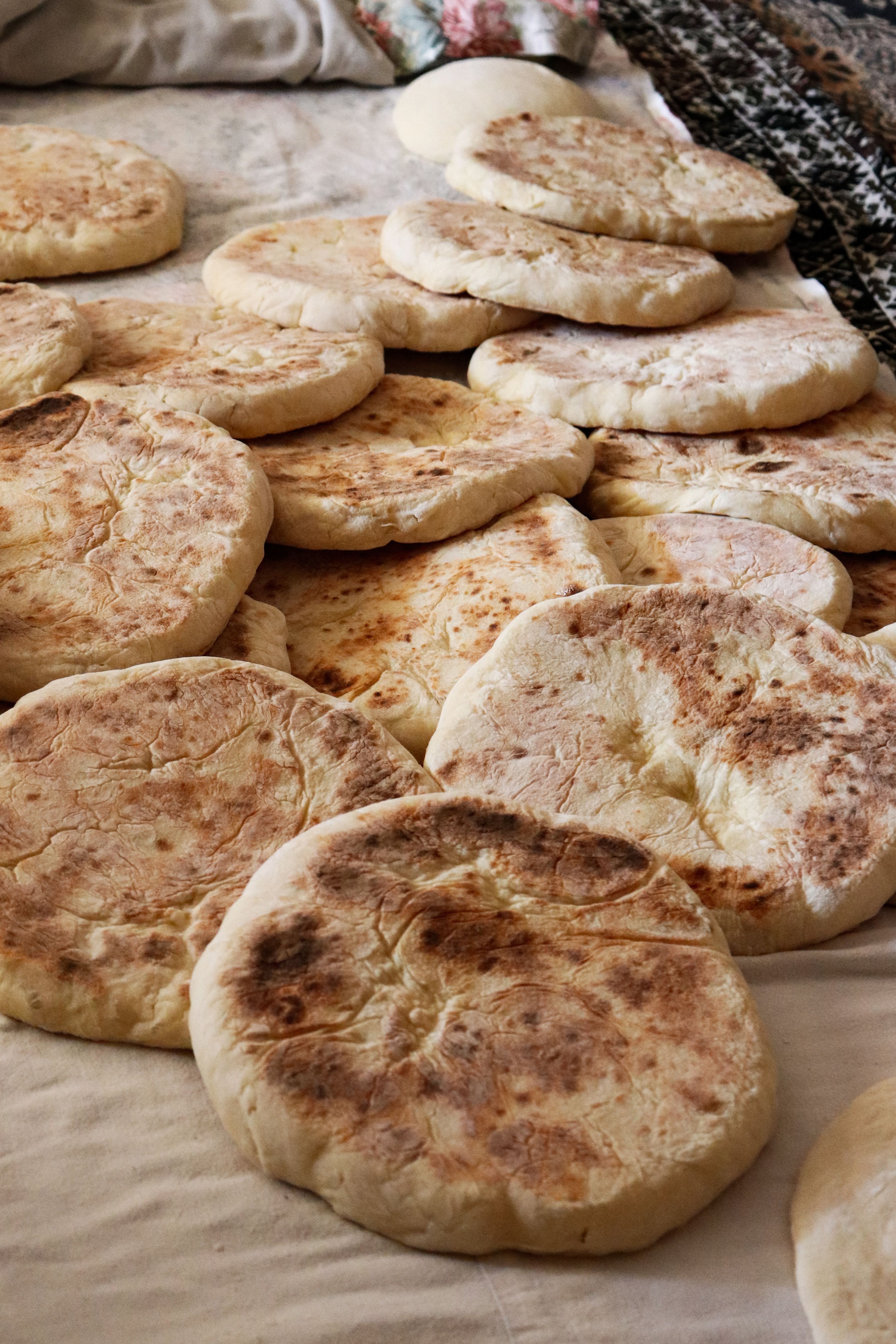 A selection of freshly baked flatbreads displayed on a cloth, showcasing homemade bread variety.
