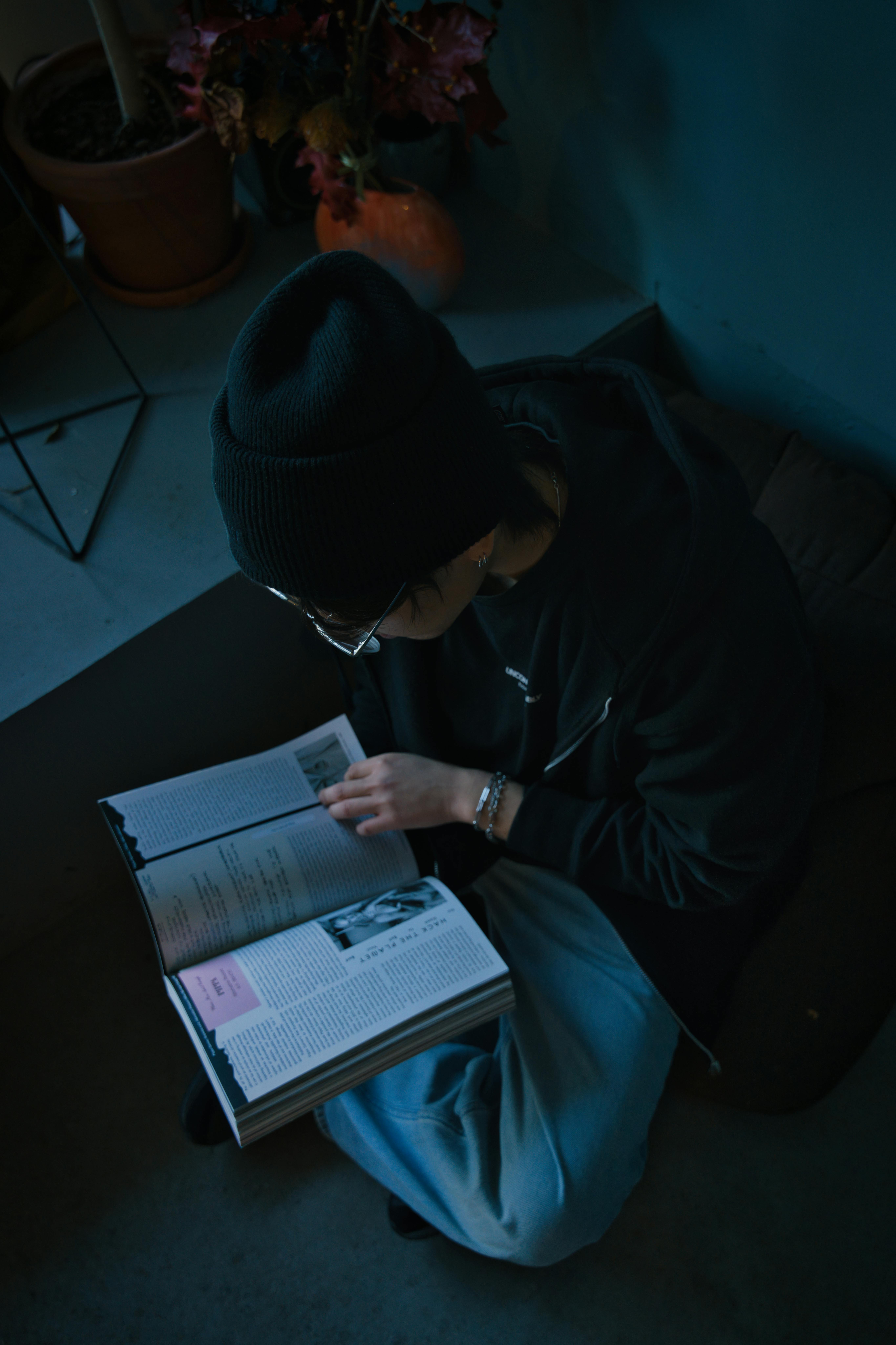 grátis Adulto lendo um livro em um ambiente interno aconchegante com iluminação intimista. Foto profissional