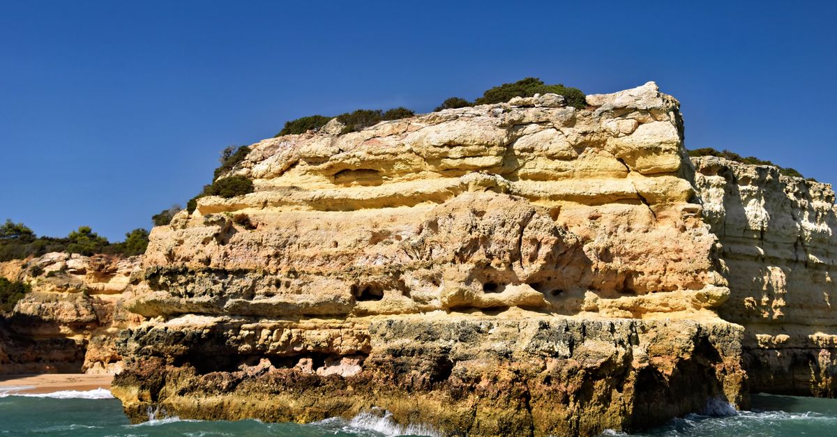 Layered sandstone cliffs and sea stacks on the Algarve coast in Portugal