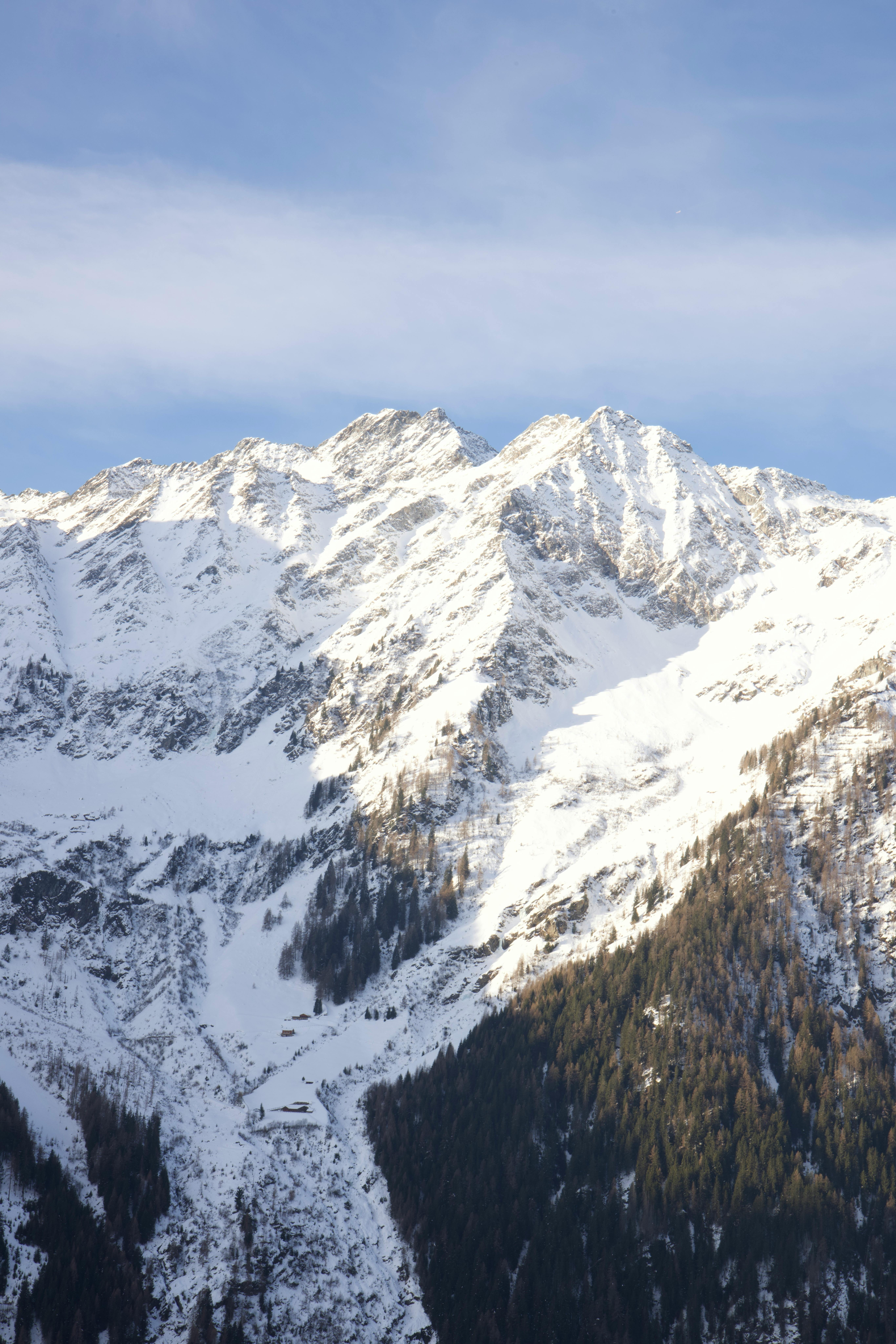 A breathtaking view of snow-covered mountain peaks under a bright sky, capturing winter's majesty.