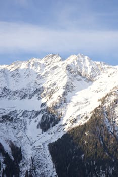 A breathtaking view of snow-covered mountain peaks under a bright sky, capturing winter's majesty.