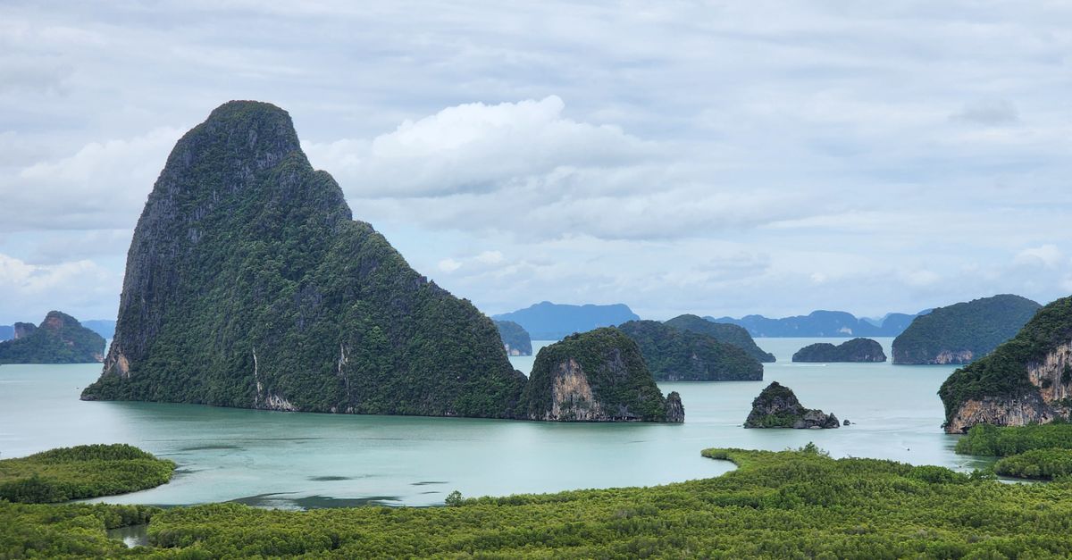 Limestone karsts and calm water in Phang Nga Bay in Thailand.