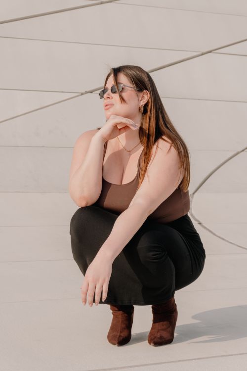 Free Stylish young woman poses confidently in outdoor urban setting. Stock Photo