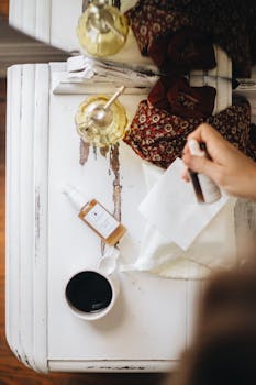 Flatlay of skincare bottle, cup of coffee, and textiles on a wooden table, exuding a cozy and natural feel.
