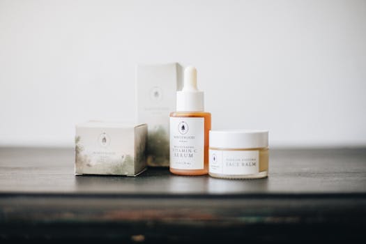 Elegant flat lay of natural skincare products, featuring a vitamin C serum and face balm.
