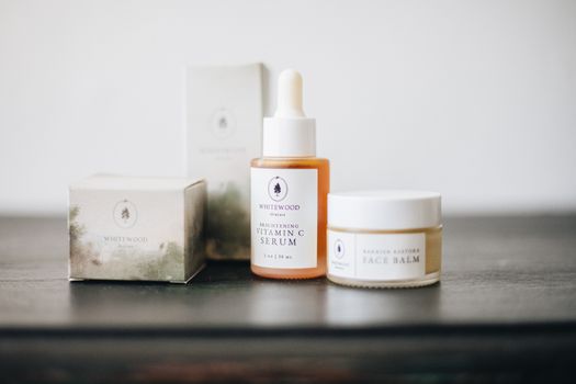 A serene presentation of vitamin C serum and face balm showcasing a minimalist skincare collection.