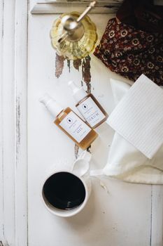 Aesthetic flatlay featuring skincare products, coffee, and warm textures for a cozy morning routine.