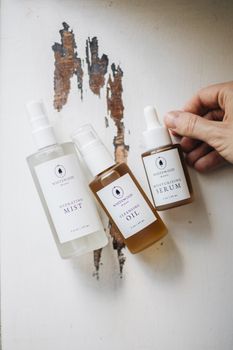 Beauty products flatlay showcasing artisan skincare on rustic wood texture.