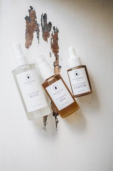 Top-down view of natural skincare products on distressed wood background.