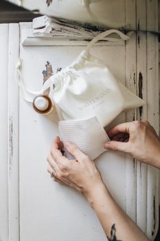 Flatlay of artisan skincare products and hands, emphasizing natural beauty.