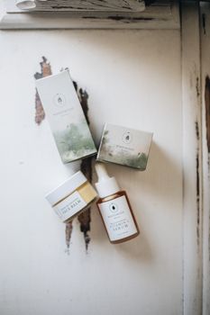 Elegant flat lay of natural skincare products featuring handmade face serum and balm.