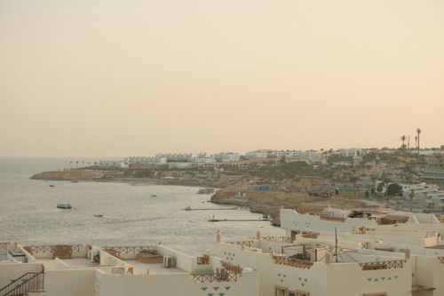 Free Breathtaking view of Sharm El Sheikh coastline at sunset with calm sea and resort buildings. Stock Photo