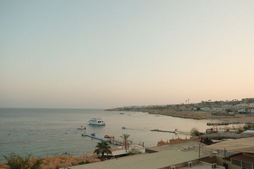 Free A tranquil sunset view of the Sharm El Sheikh coastline with a boat and tranquil waters. Stock Photo