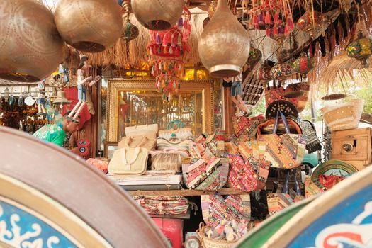 Vibrant display of handcrafted bags and decor at a lively outdoor market, featuring traditional craftsmanship.