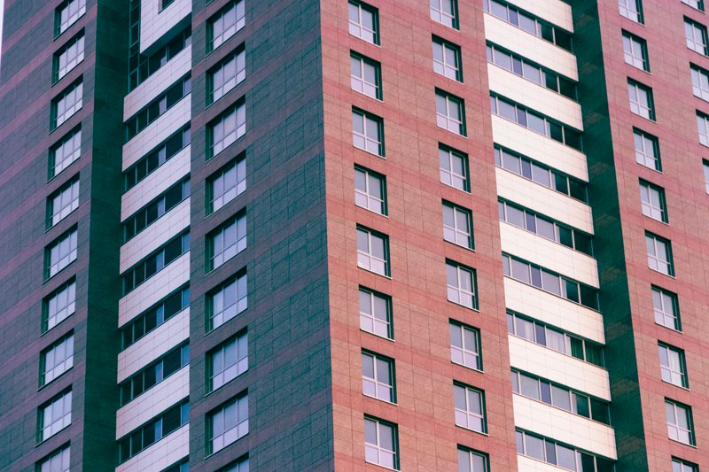 Close-up of a modern high-rise building with glass windows and geometric patterns.