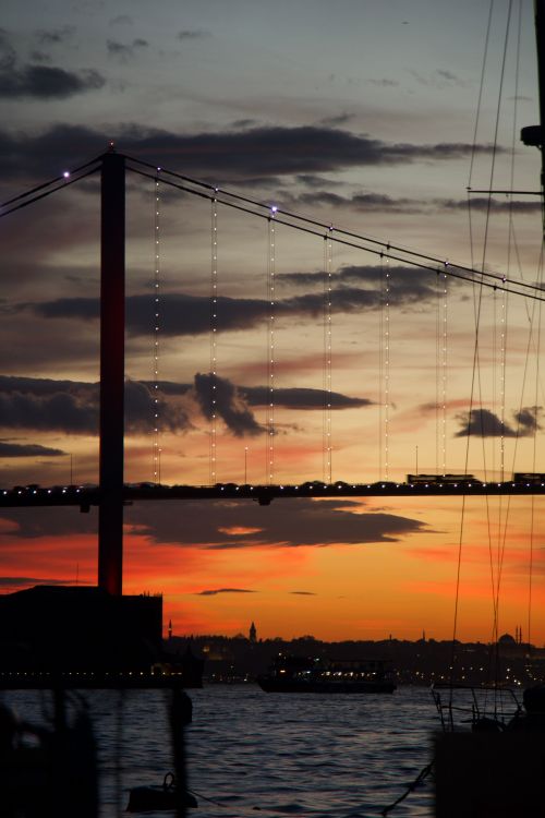 Free Stunning sunset view of the Bosphorus Bridge in Istanbul with vibrant colors reflecting on the water. Stock Photo