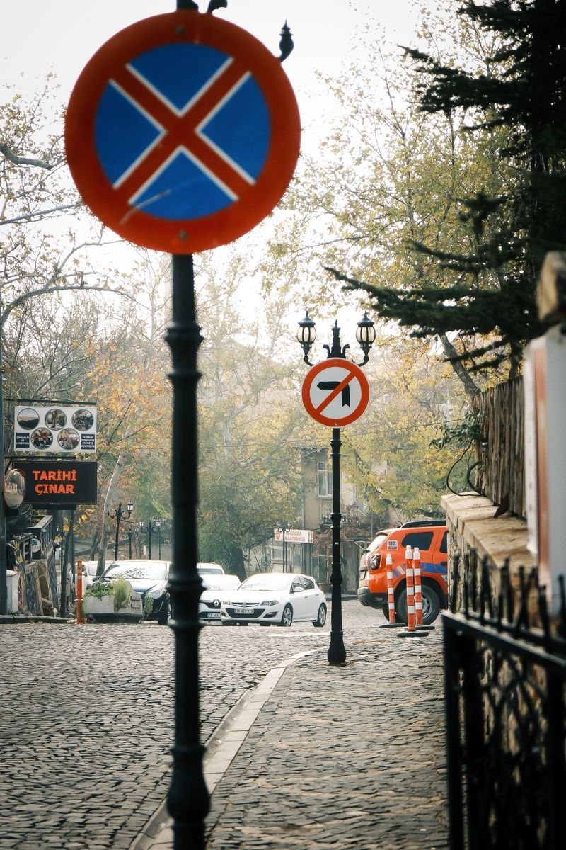 Stradă europeană pavată cu semne de circulație și mașini parcate