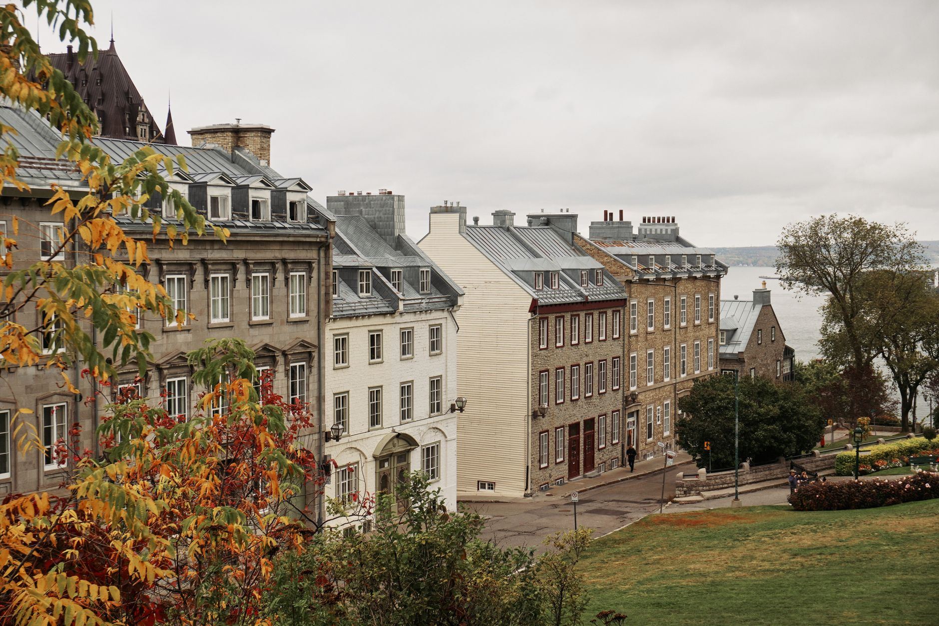Picturesque view of historic buildings in Old Quebec City during fall with colorful trees.