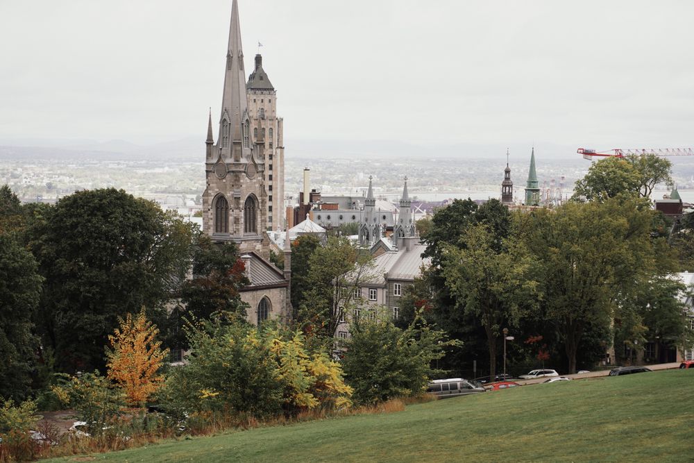 Vista de Quebec con iglesia neogótica y follaje de otoño desde una colina