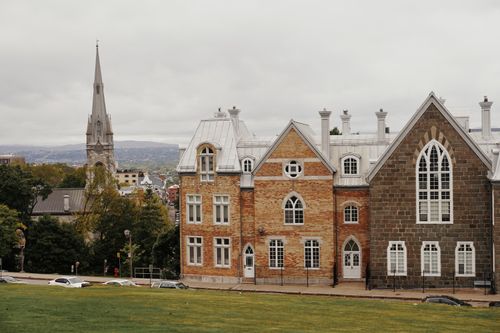 Free Historic architecture with Gothic Revival church in an urban landscape, overcast sky. Stock Photo