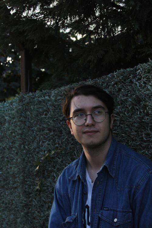 Free Portrait of a young man wearing glasses and a denim jacket standing outdoors in Darıca, Kocaeli, Türkiye. Stock Photo