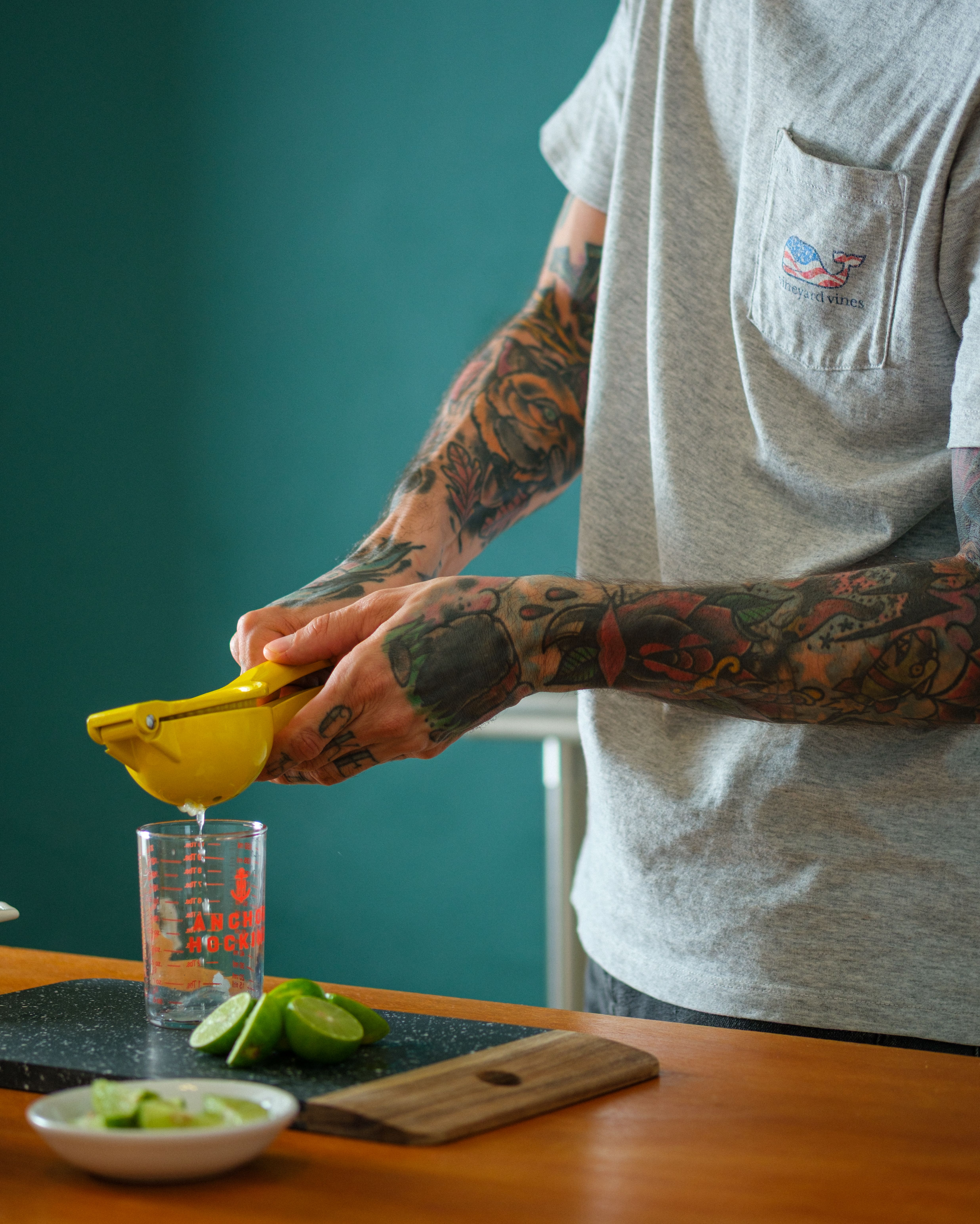 Tattooed Hands Squeezing Limes in Kitchen · Free Stock Photo