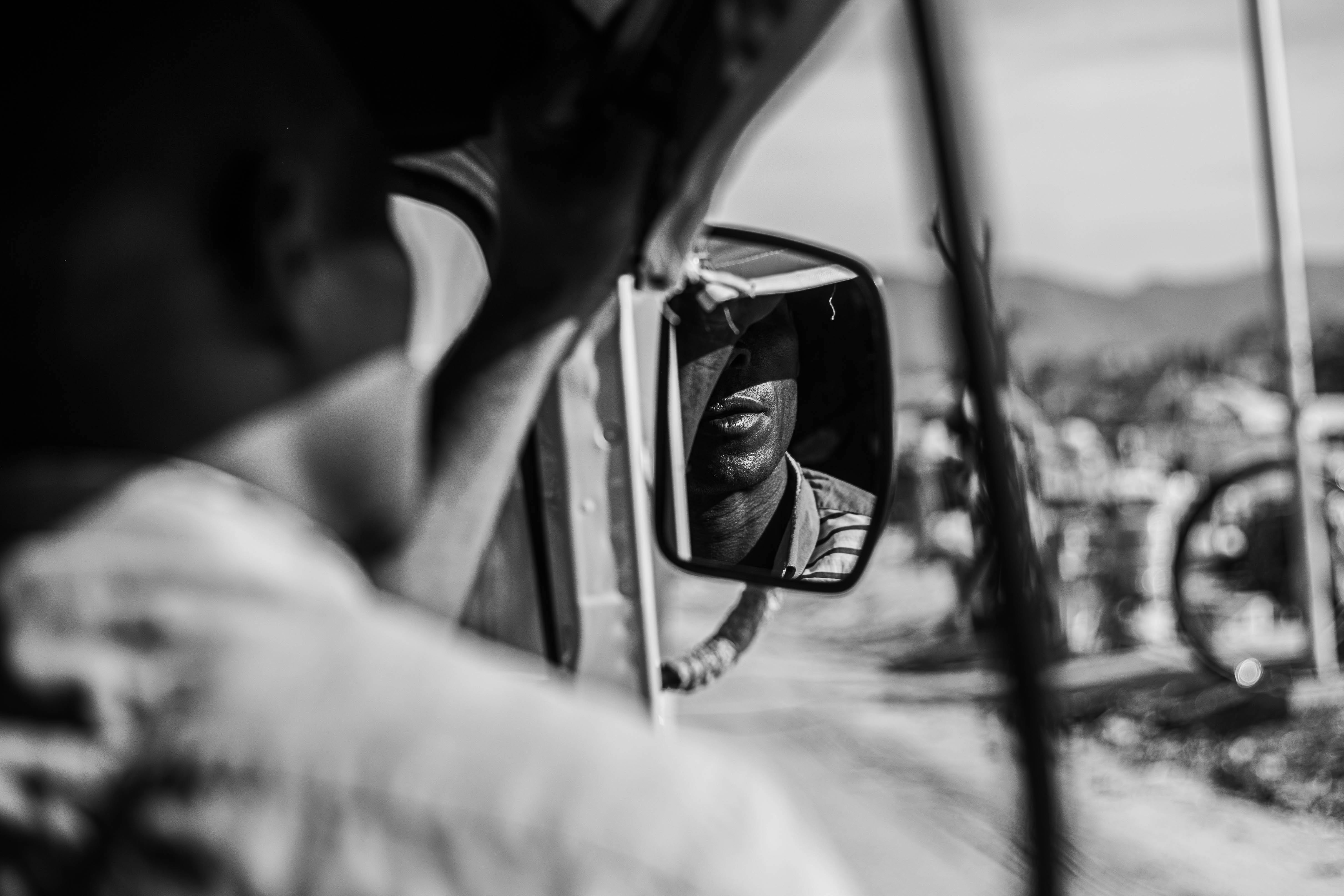 Gratuit Un portret contemplativ alb-negru realizat dintr-o oglindă retrovizoare care reflectă gânduri profunde Fotografie de stoc