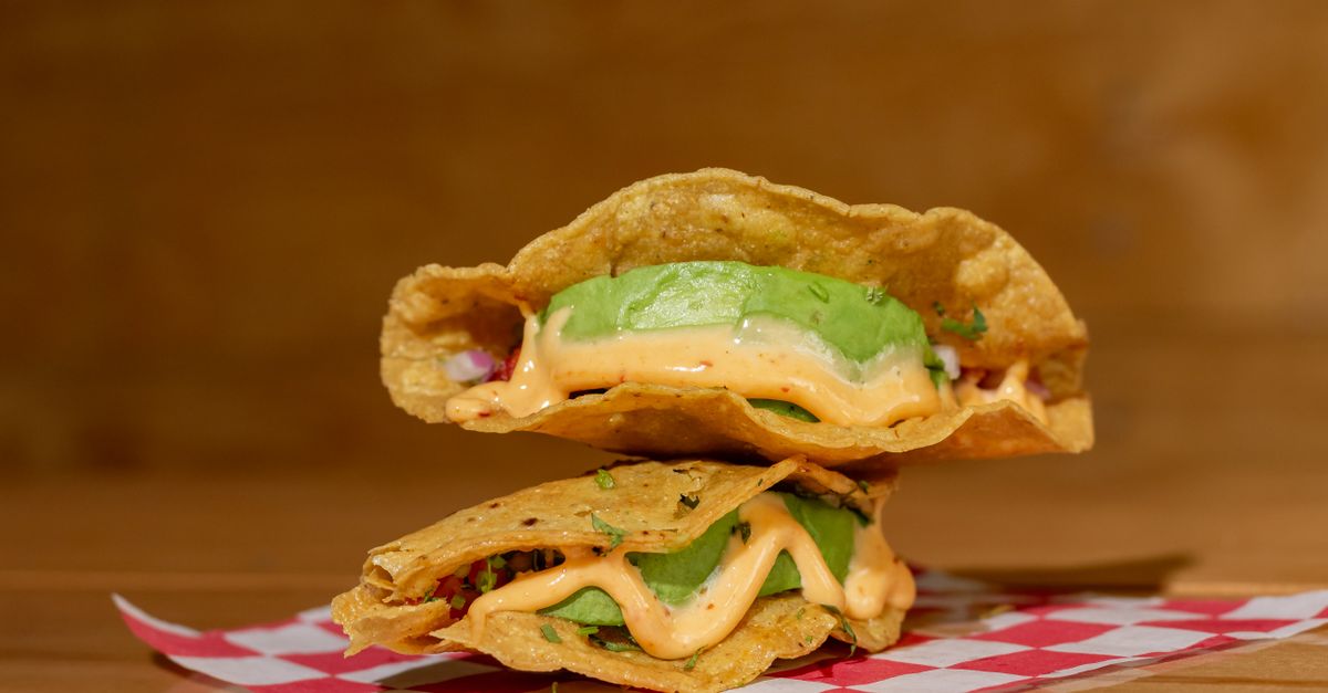 vibrant lentil walnut taco "meat" in a crispy shell with fresh toppings